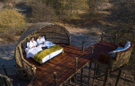 Ein Paar liegt im rundum offenen Sky Bed der Ghao Dham Lodge m-Dhao Luxuschalet mit Star Bed