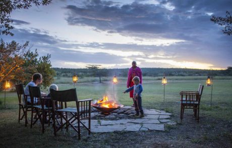 Frau, zwei Kinder und Masai vor Lagerfeuer in Kenia