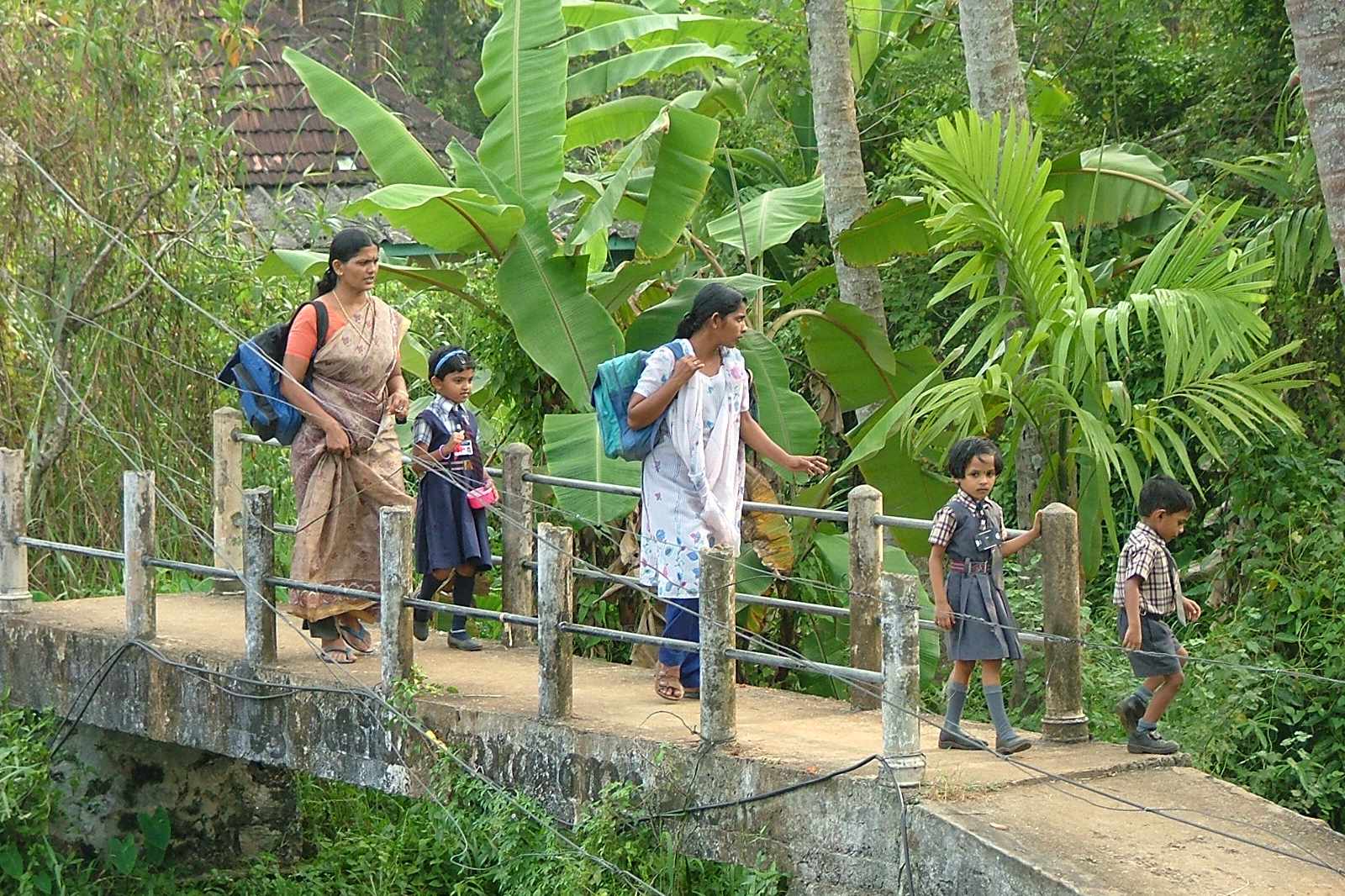 Familie auf einer Brücke über einen Wasserkanal in den Kerala Backwaters