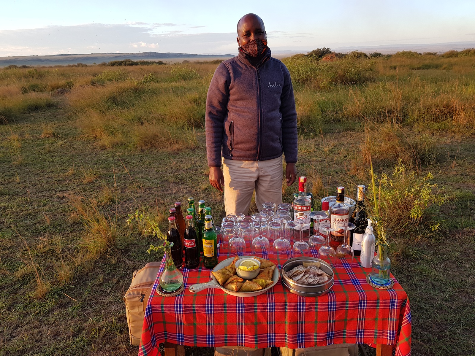 Guide steht vor einem gedeckten Tisch in der Savanne Kenias