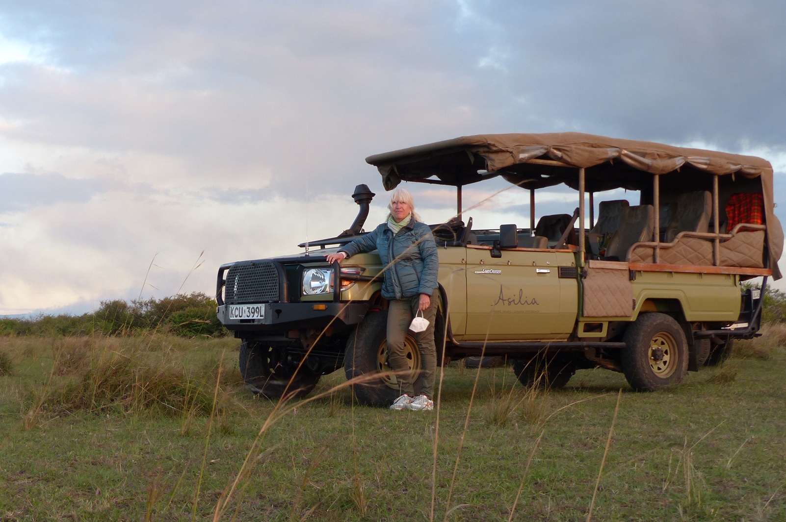 Frau in Kenia vor offenem 4x4 Safarifahrzeug mit Elektroantrieb