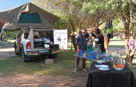 Selbstfahrer Fahrzeug mit aufgeklapptem Dachzelt, Klapptisch, 2 Personen am Kocherund