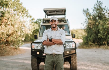 Guide steht vor einem Safari Fahrzeug